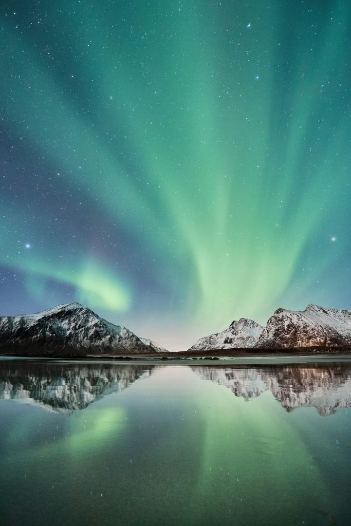 "Experience the mesmerizing beauty of the Northern Lights over snow-capped mountains and pristine waters. Witness the Aurora Borealis' breathtaking display in the Arctic sky, perfect for nature lovers and photographers seeking the ultimate night sky adventure."

