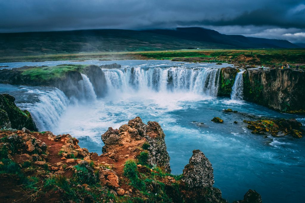 "Discover the breathtaking beauty of Iceland's Godafoss waterfall. This stunning natural wonder, set against a dramatic landscape of lush greenery and rugged cliffs, offers a mesmerizing view of cascading waters. Perfect for travel enthusiasts and nature lovers, Godafoss is a must-visit destination in Iceland. Explore the serene and majestic scenery, ideal for photography and outdoor adventures."

