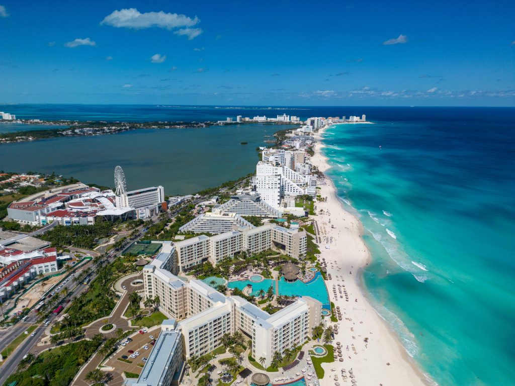 This image captures the stunning beachfront and vibrant cityscape of Cancun, Mexico. Known for its beautiful turquoise waters, white sandy beaches, and bustling resort area, Cancun is a top destination for tourists seeking both relaxation and adventure in the heart of the Mexican Caribbean.